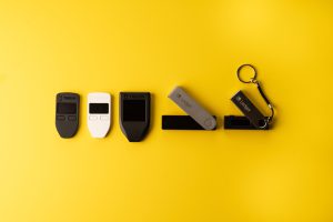 Top view of different cryptocurrency hardware wallets on the yellow background - a safe storage solution for holding bitcoin and other alt coins